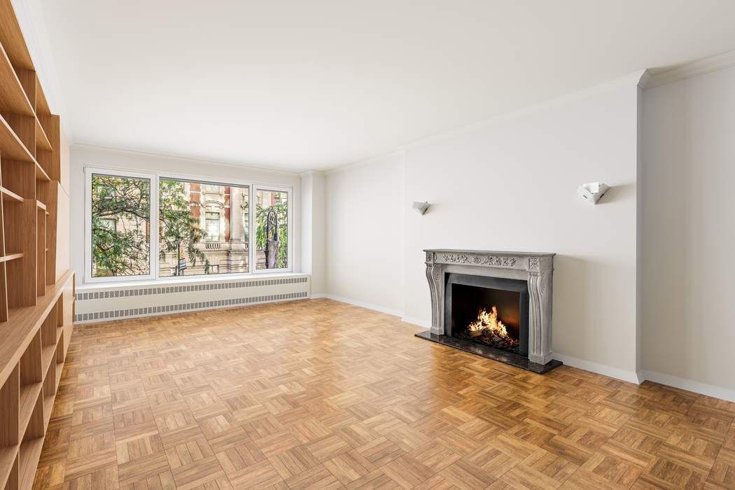 1050 5th Avenue, Unit 3B Manhattan, NY 10028 - Photo 2 of 13 a view of an empty room with a fireplace and a window