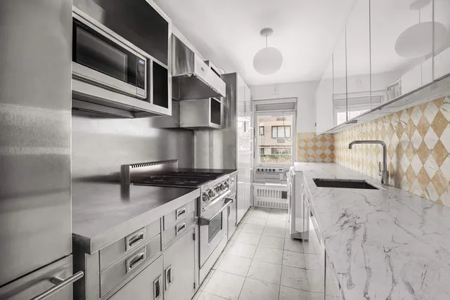 a kitchen with stainless steel appliances granite countertop a stove and cabinets