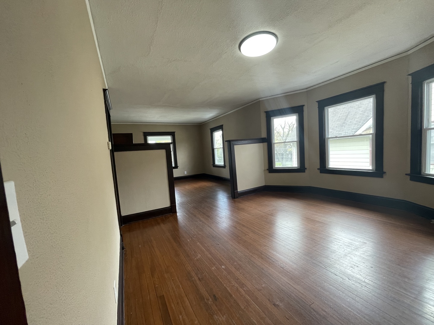 710 North Poplar Street, Unit 2 Waukegan, IL 60085 - Photo 9 of 16 an empty room with wooden floor and windows