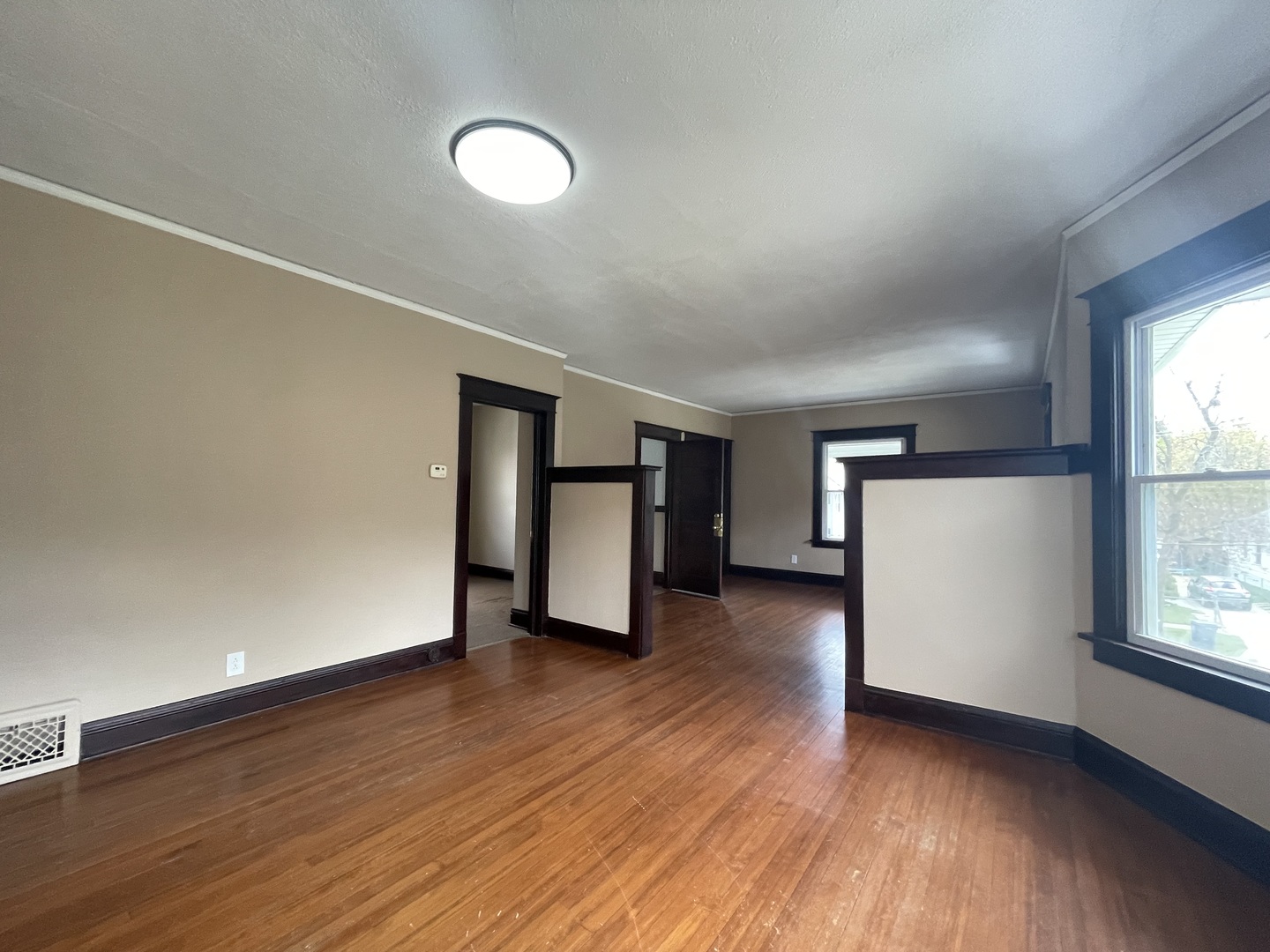 710 North Poplar Street, Unit 2 Waukegan, IL 60085 - Photo 10 of 16 an empty room with wooden floor and windows