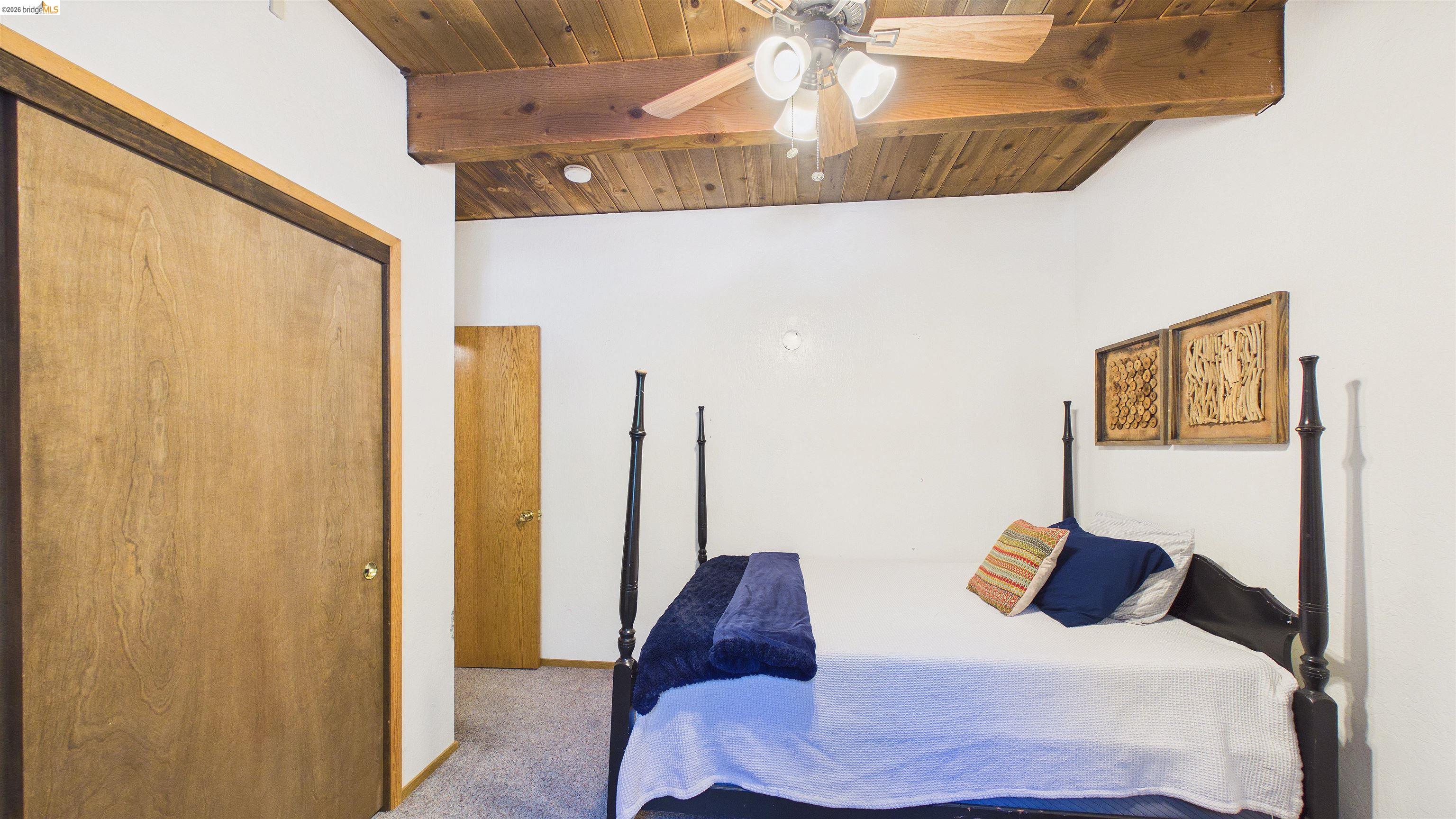 26570 Crystal Road Long Barn, CA 95335 - Photo 14 of 39 Room featuring a wood-panel vaulted ceiling with exposed beams, ceiling fan, and carpeted flooring