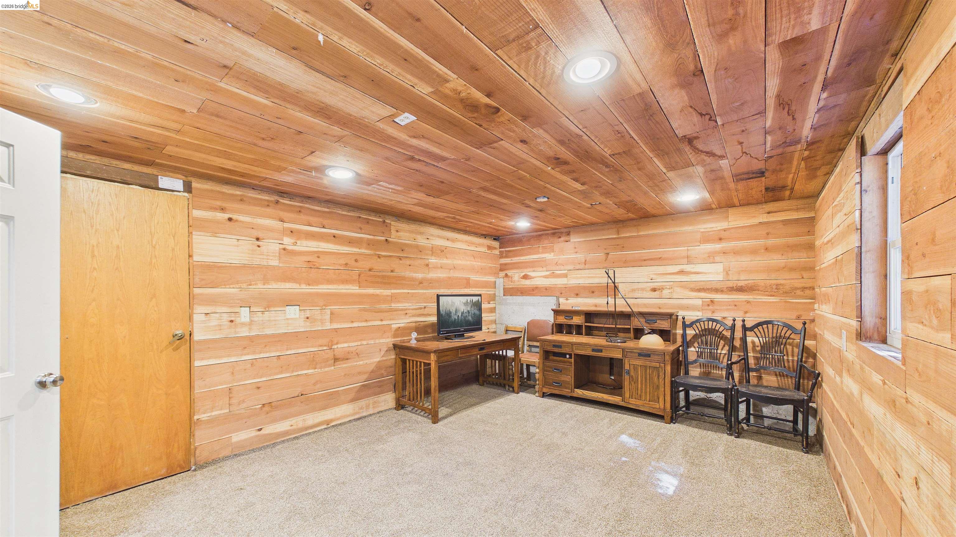 26570 Crystal Road Long Barn, CA 95335 - Photo 25 of 39 Spacious room featuring wood-finish walls and ceiling, recessed lighting, a single window, and neutral carpet flooring