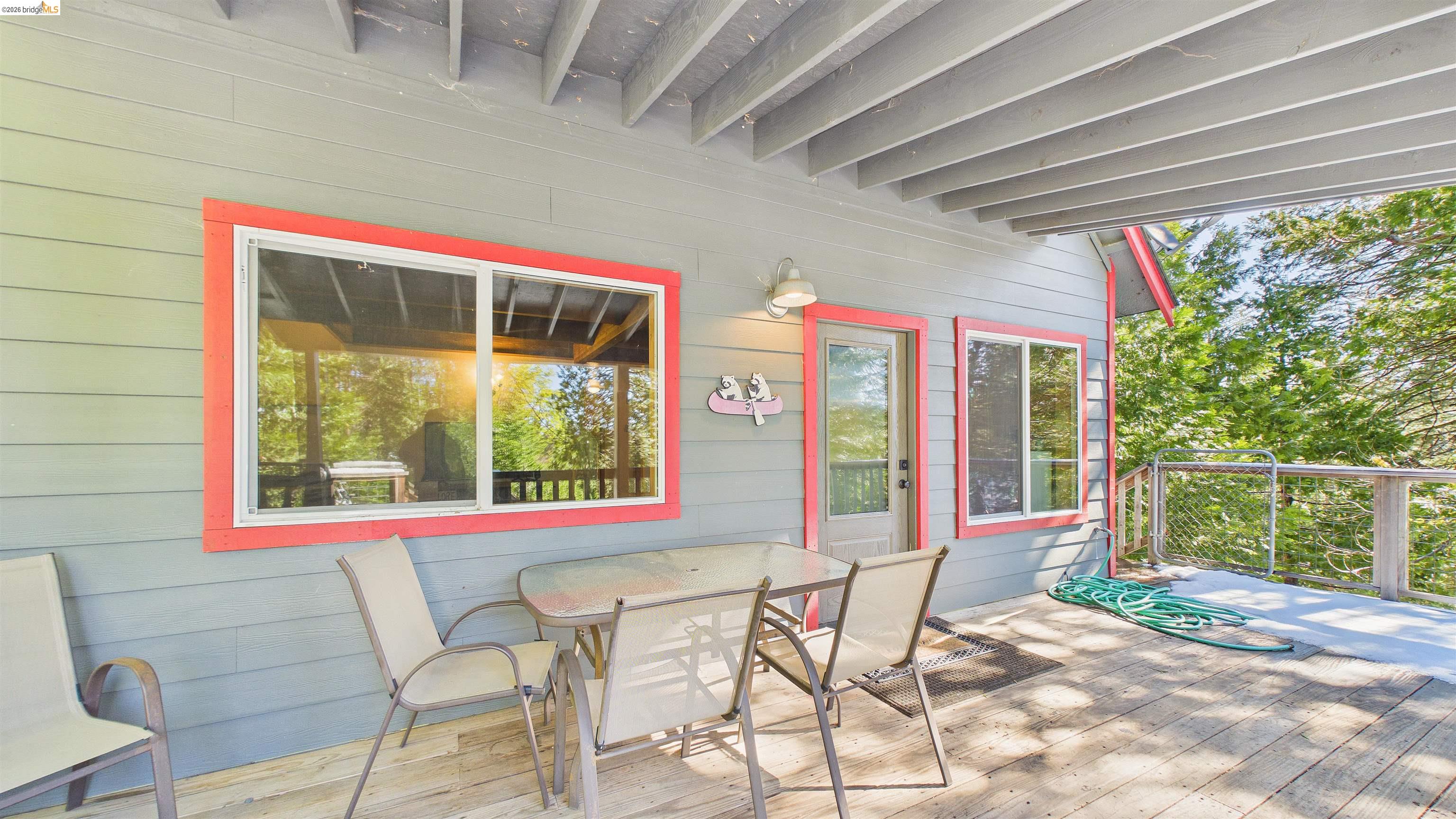 26570 Crystal Road Long Barn, CA 95335 - Photo 6 of 39 Covered outdoor deck featuring wood flooring and a light gray exterior wall