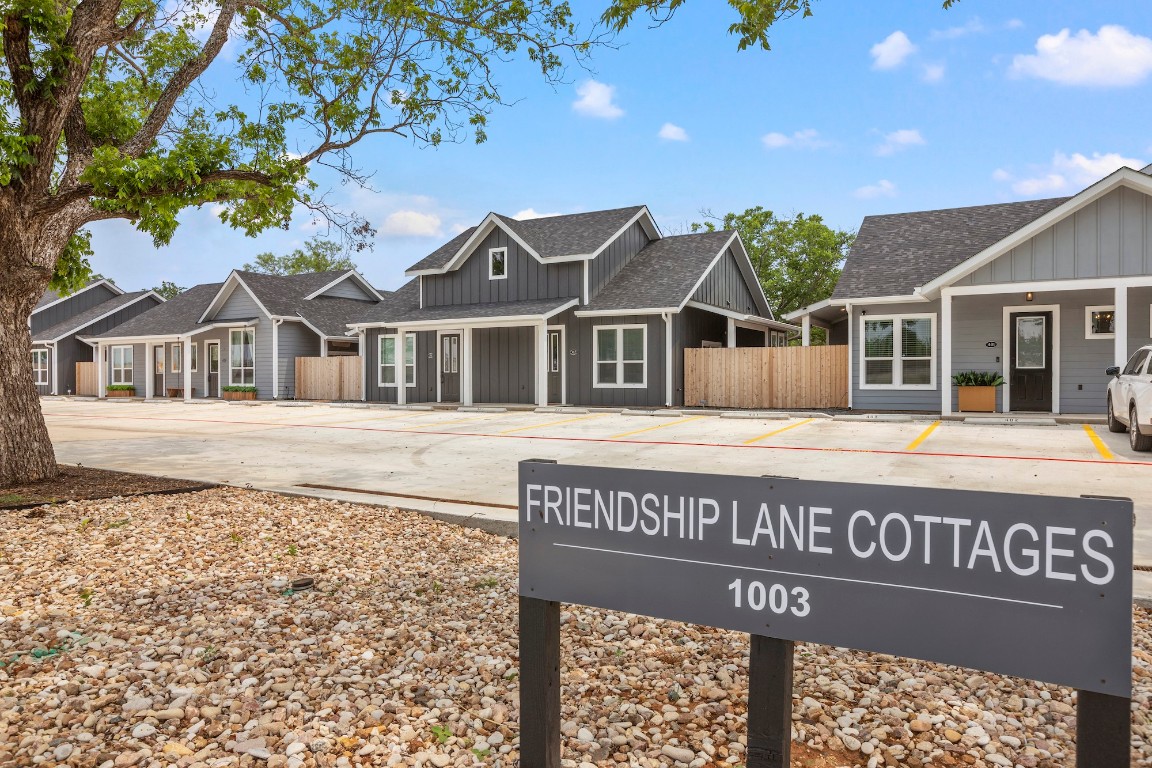 a view of a white house with a large tree