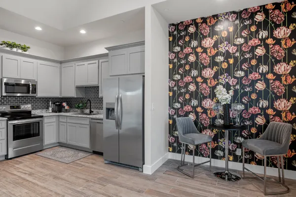 a kitchen with stainless steel appliances granite countertop a refrigerator and a stove top oven