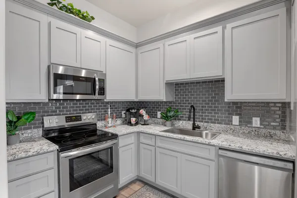 a kitchen with sink a microwave and cabinets