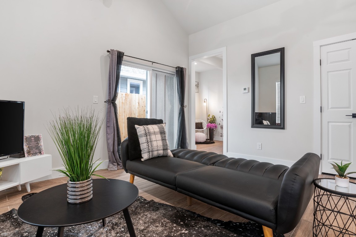 1003 Friendship Lane, Unit 301 Fredericksburg, TX 78624 - Photo 9 of 19 a living room with furniture potted plant and a wooden floor