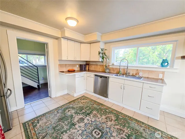 a large white kitchen with sink a stove and a refrigerator