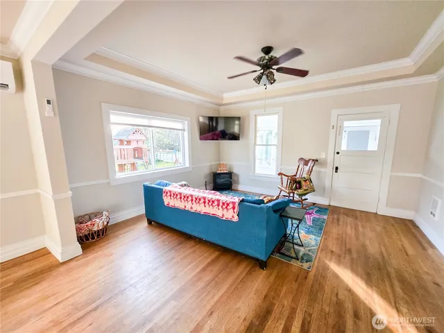 a view of an empty room with window and wooden floor