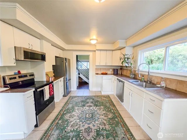 a kitchen with stainless steel appliances granite countertop a stove a sink and a refrigerator