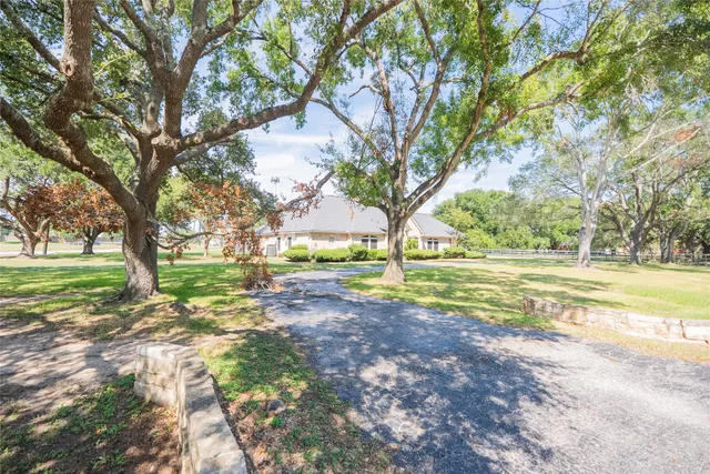 a view of a livingroom with a fireplace a chandelier fan and wooden floor