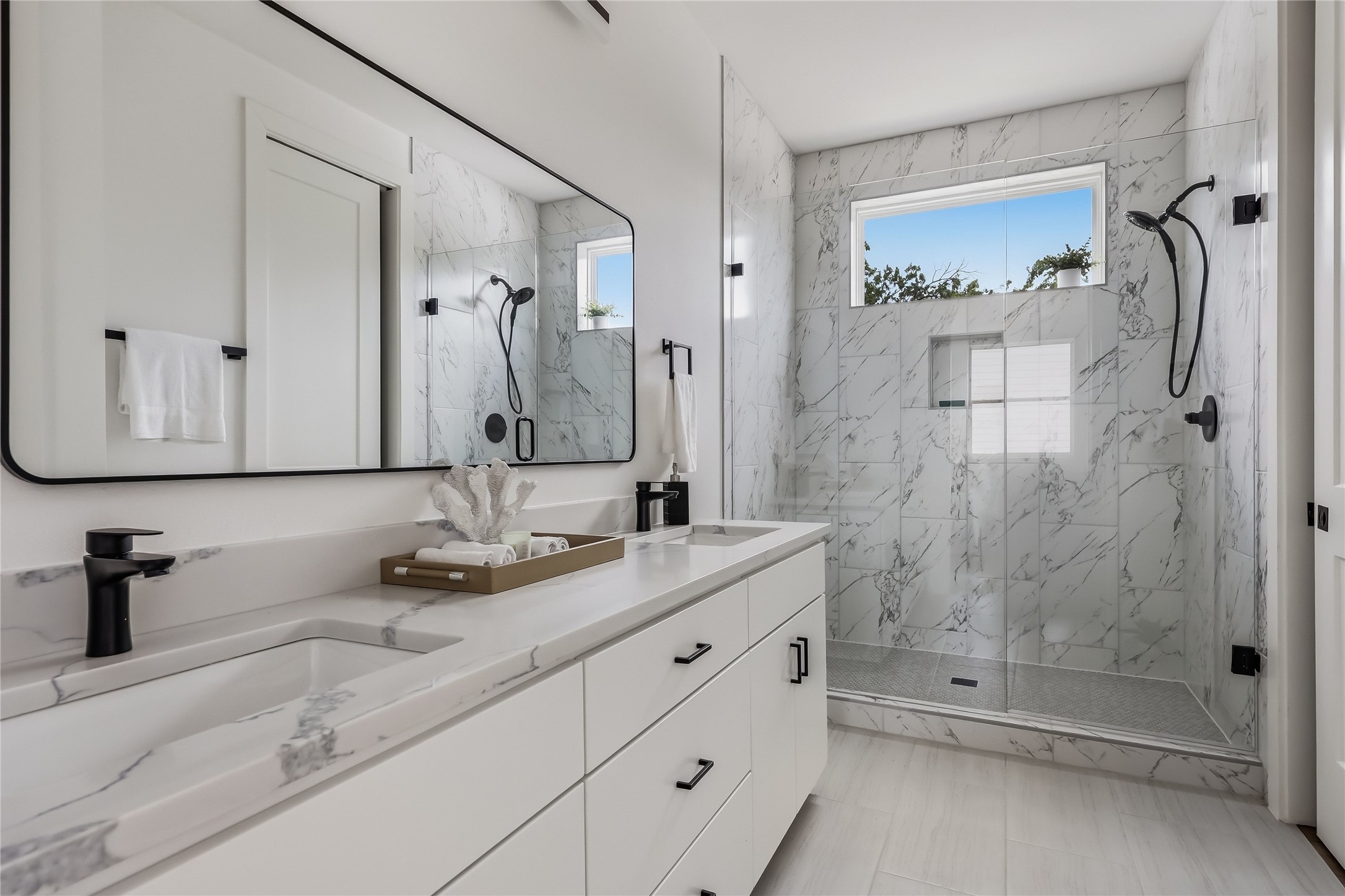 6809 Porter Street, Unit 1 Austin, TX 78741 - Photo 24 of 40 Dual vanities and a spacious glass-enclosed shower create a modern and functional bathroom oasis.