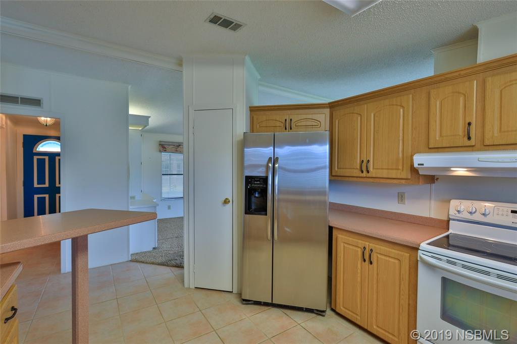803 Navigators Way Edgewater, FL 32141 - Photo 11 of 27 a kitchen with stainless steel appliances granite countertop a refrigerator and a stove top oven