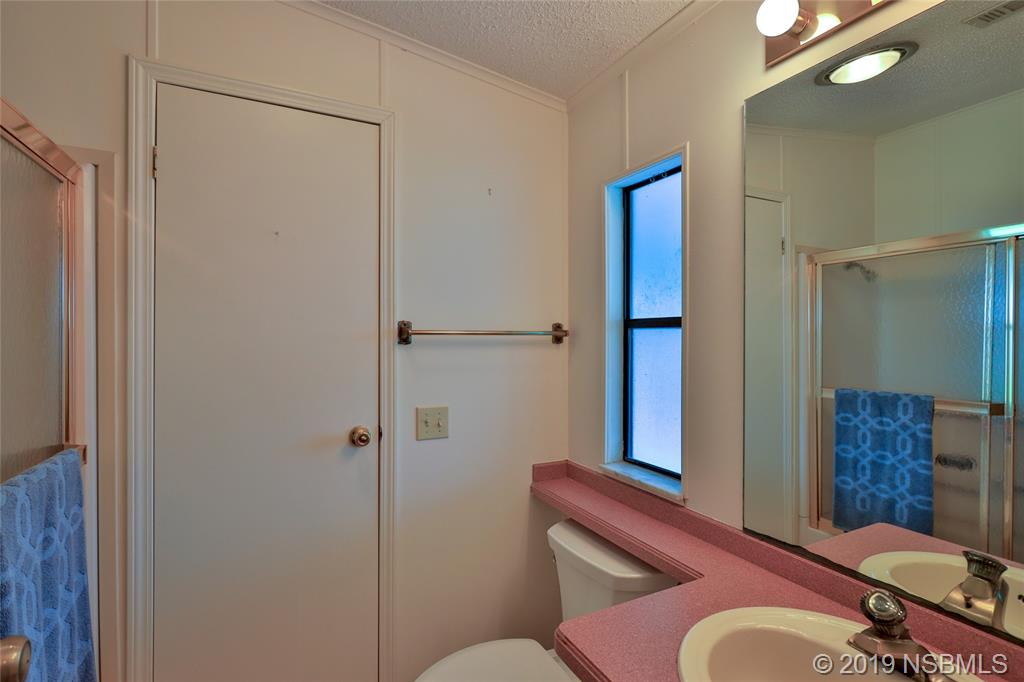 803 Navigators Way Edgewater, FL 32141 - Photo 13 of 27 a bathroom with a sink mirror vanity and toilet