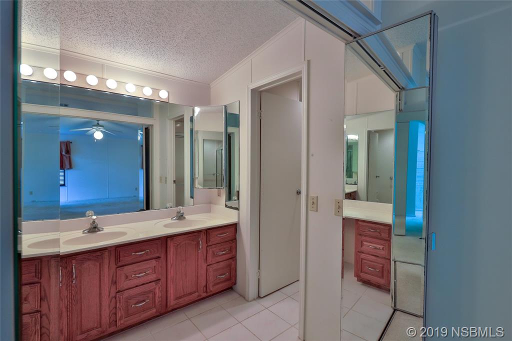 803 Navigators Way Edgewater, FL 32141 - Photo 19 of 27 a spacious bathroom with a double vanity sink and a mirror