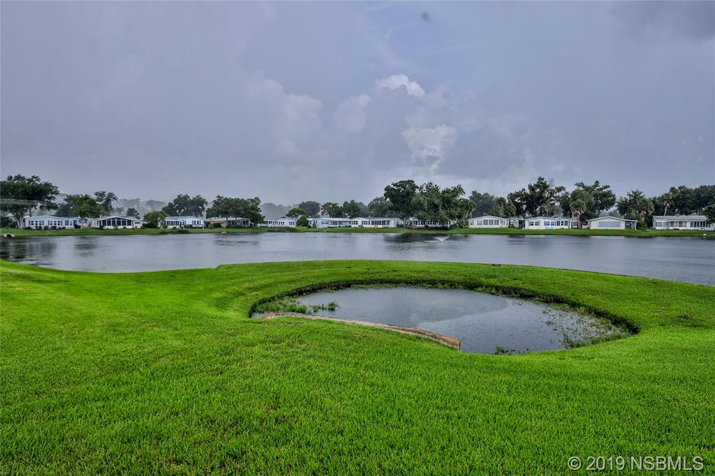 803 Navigators Way Edgewater, FL 32141 - Photo 3 of 27 a view of a lake with houses in the background