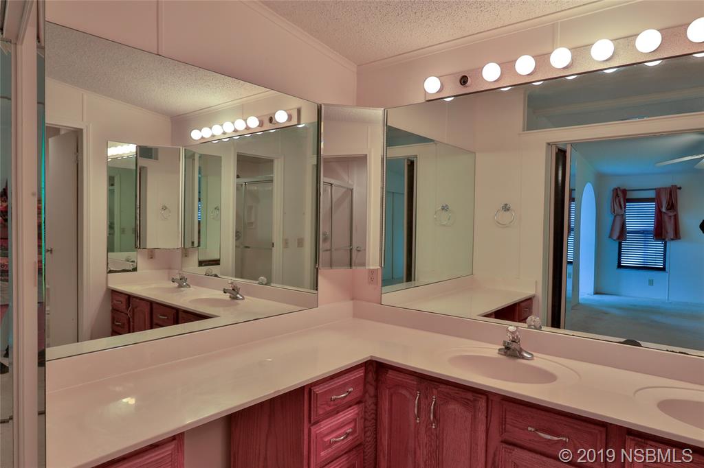 803 Navigators Way Edgewater, FL 32141 - Photo 21 of 27 a bathroom with double vanity sinks and a mirror