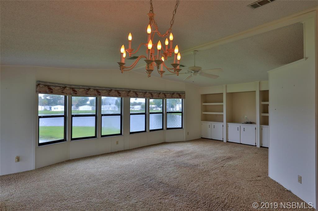 803 Navigators Way Edgewater, FL 32141 - Photo 9 of 27 a view of an empty room with a window and fireplace