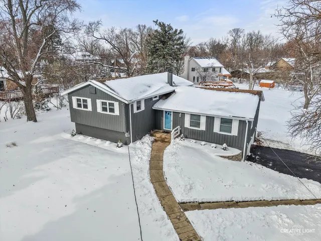 a view of a house with a yard covered in snow