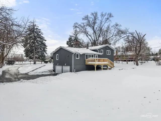 a front view of a house with a yard covered in snow