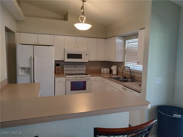 a kitchen with a refrigerator a stove a sink and a stove