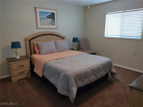 a large bed sitting in a bedroom next to a window