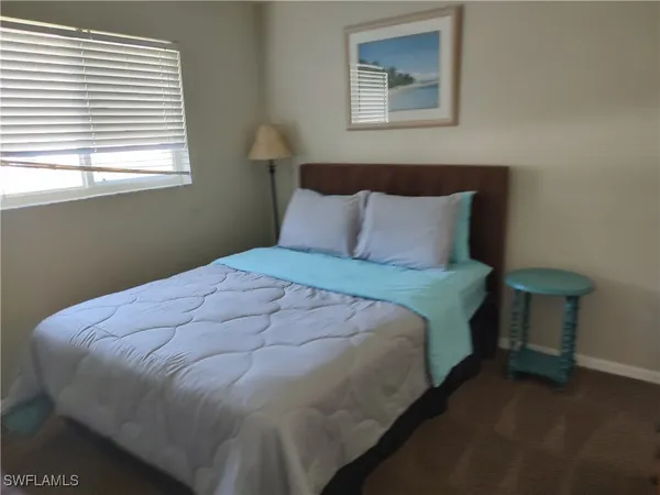 a large bed sitting in a bedroom next to a window