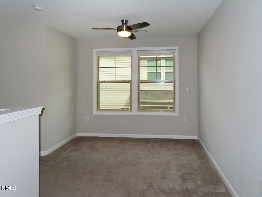 1217 Compass Drive Durham, NC 27713 - Photo 13 of 29 an empty room with chandelier fan and windows