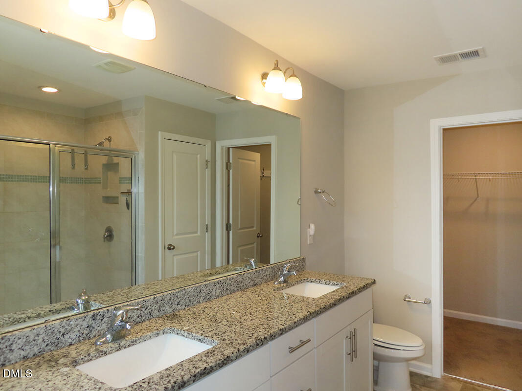 1217 Compass Drive Durham, NC 27713 - Photo 16 of 29 a bathroom with a granite countertop sink a toilet a large mirror and shower