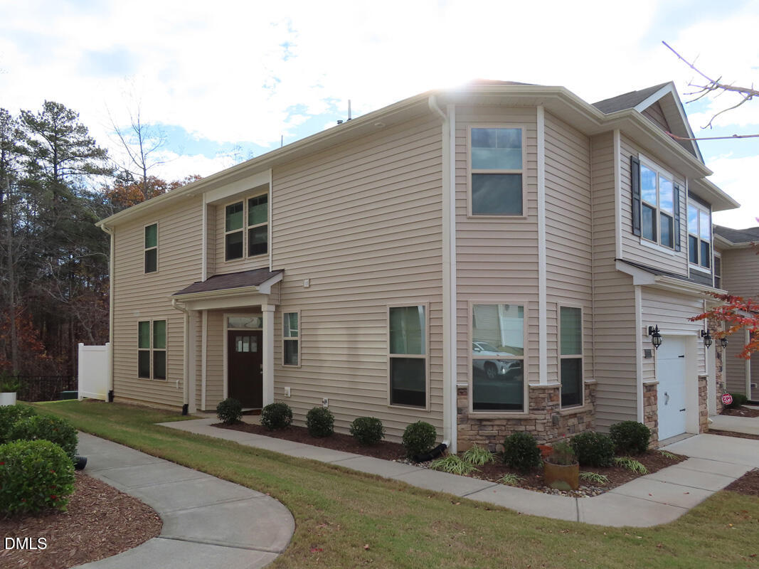 1217 Compass Drive Durham, NC 27713 - Photo 26 of 29 a view of a white house with many windows next to a yard