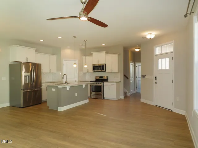 a kitchen with stainless steel appliances kitchen island granite countertop a refrigerator and a stove top oven