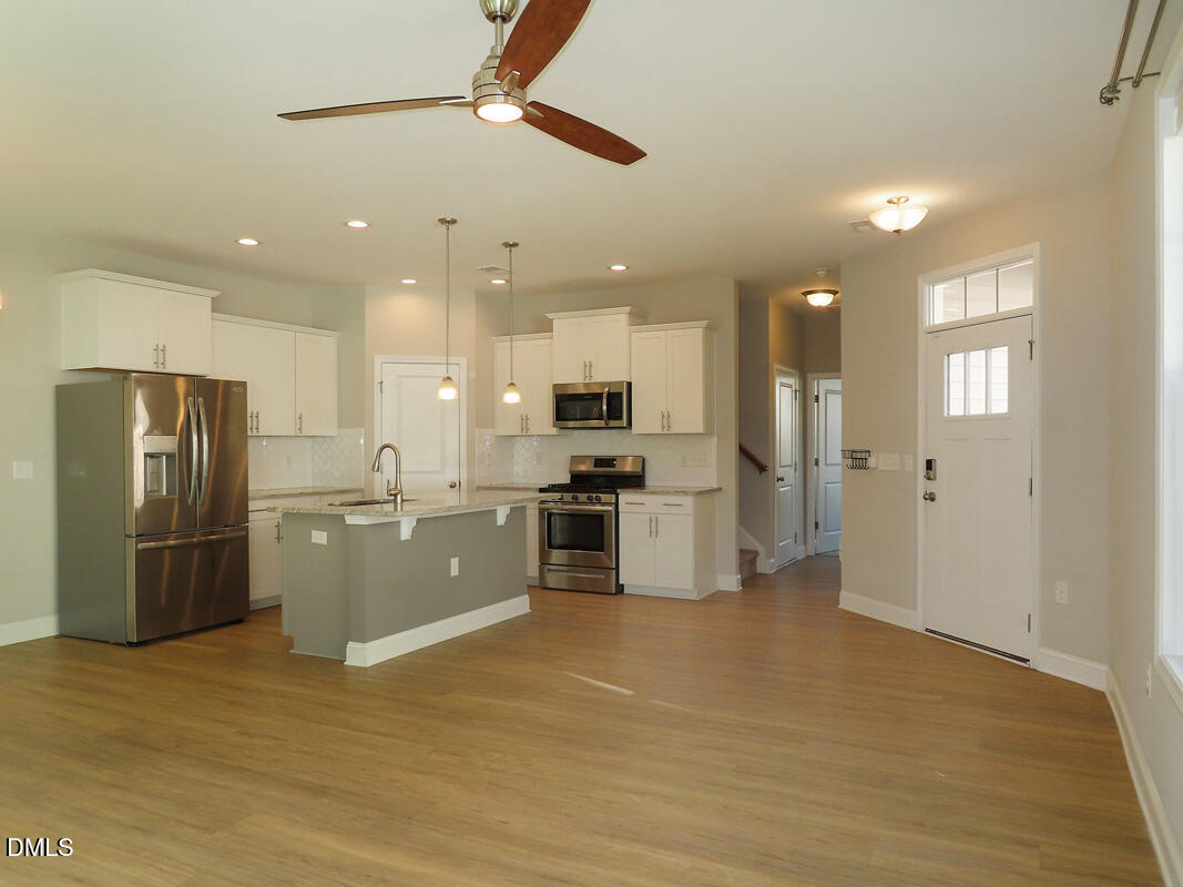 1217 Compass Drive Durham, NC 27713 - Photo 3 of 29 a kitchen with stainless steel appliances kitchen island granite countertop a refrigerator and a stove top oven