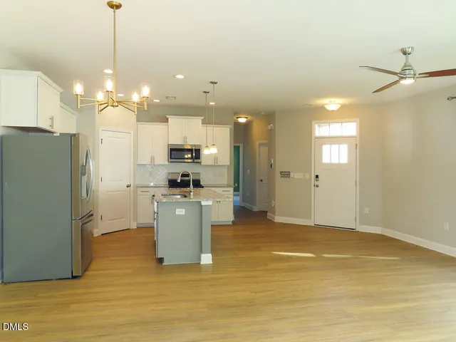 a view of a kitchen with refrigerator and cabinets
