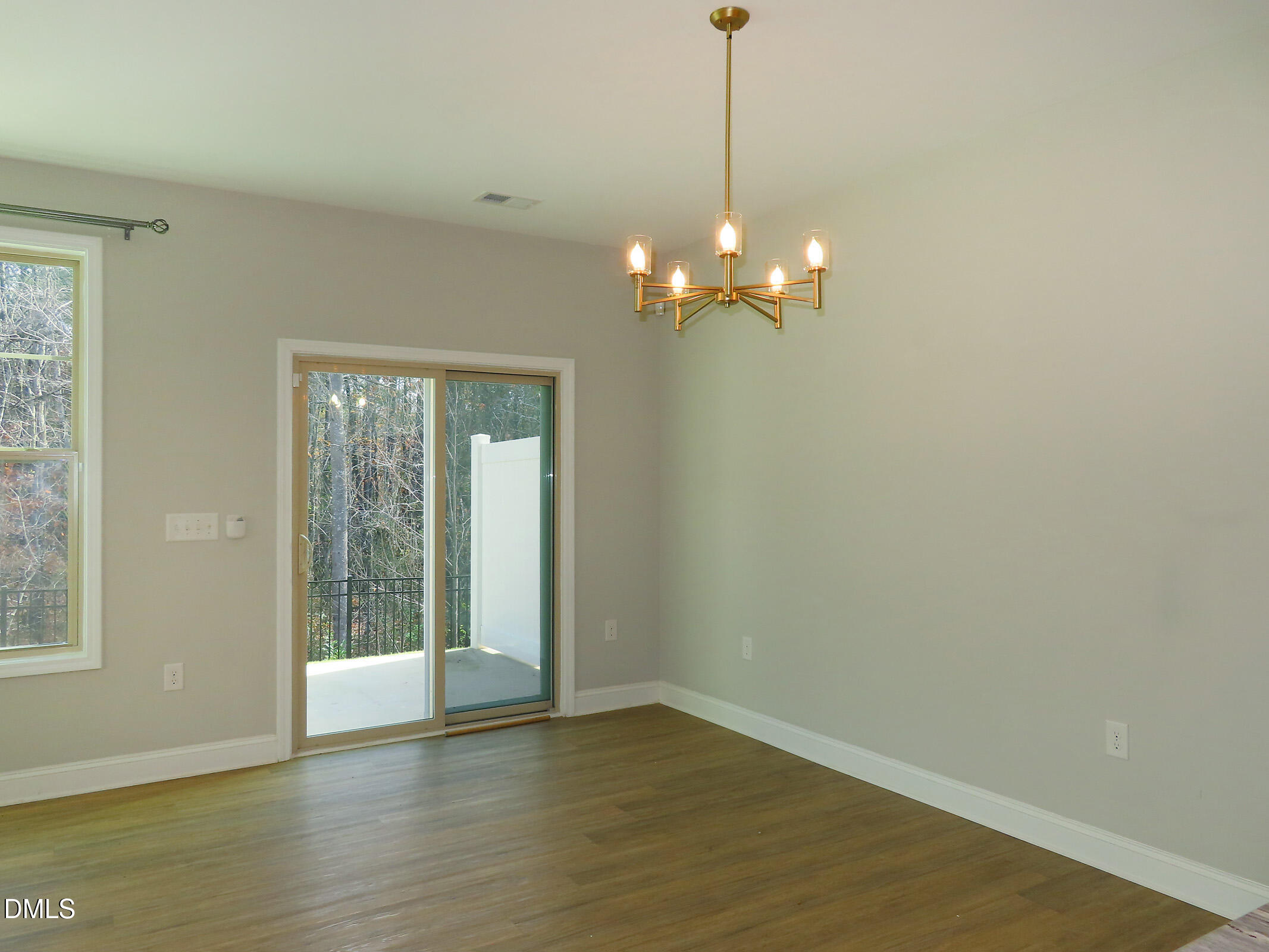 1217 Compass Drive Durham, NC 27713 - Photo 7 of 29 a view of an empty room with wooden floor and a window