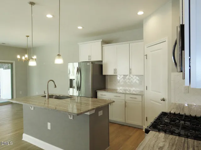 a kitchen with kitchen island a sink stainless steel appliances and cabinets