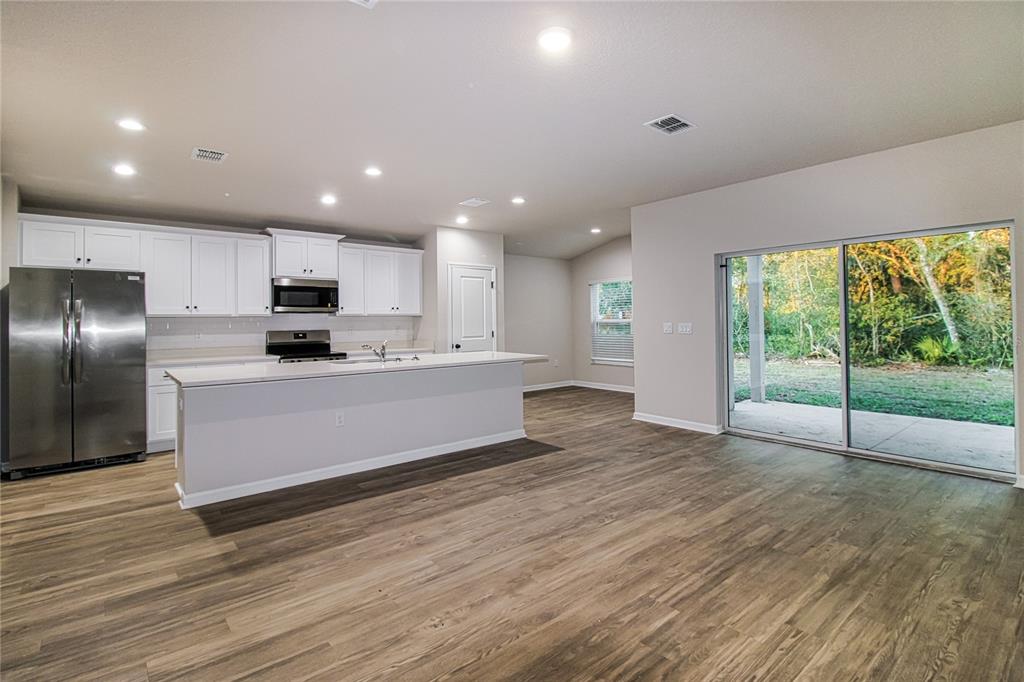 46 Ash Road Ocala, FL 34472 - Photo 4 of 20 a large kitchen with stainless steel appliances a large counter top a stove and a wooden floors