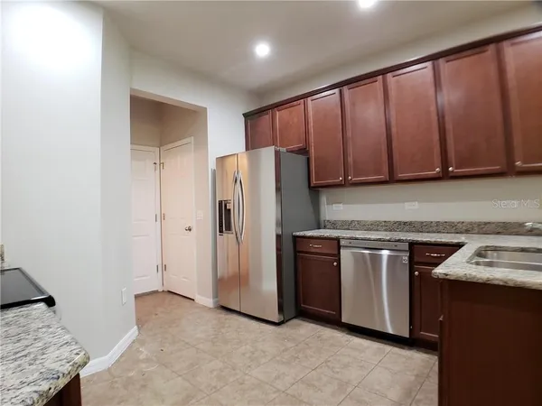 a kitchen with stainless steel appliances granite countertop a refrigerator a sink and a stove