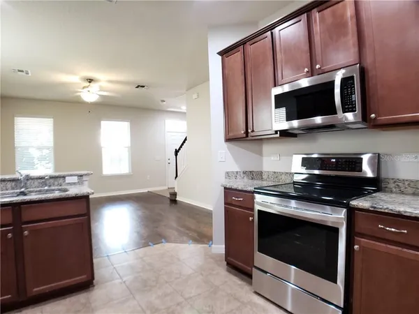 a kitchen with stainless steel appliances granite countertop a stove microwave and sink