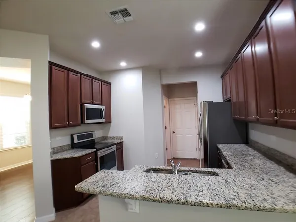 a kitchen with kitchen island granite countertop counter top space cabinets and stainless steel appliances