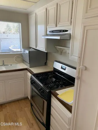 a kitchen with granite countertop a stove and a sink