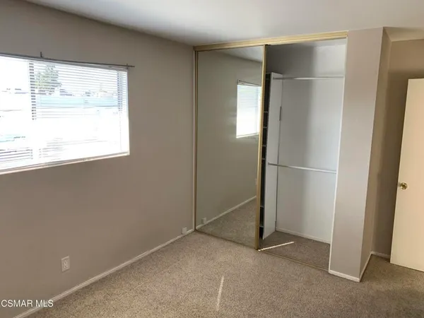 an empty room with windows and closet