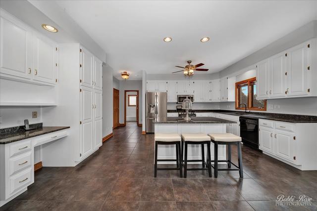 2809 Turnberry Road St. Charles, IL 60174 - Photo 9 of 21 a kitchen with granite countertop a table chairs microwave and cabinets