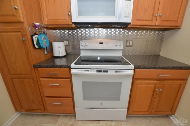 a room with stainless steel appliances kitchen island granite countertop a sink and a cabinets