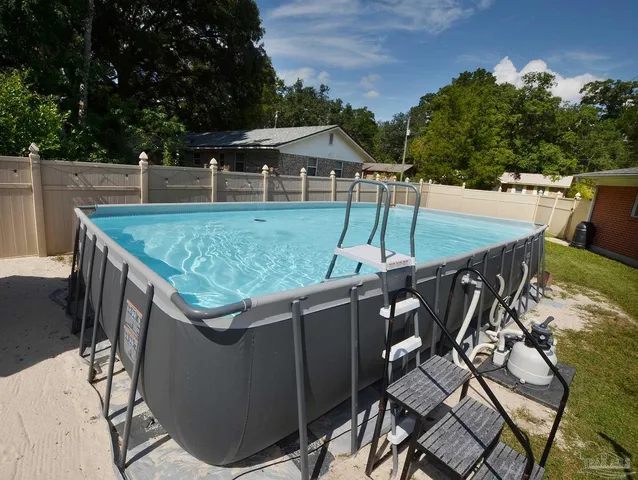 a front view of house with yard and trees in the background