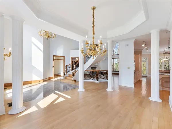 an empty room with wooden floor fireplace and windows