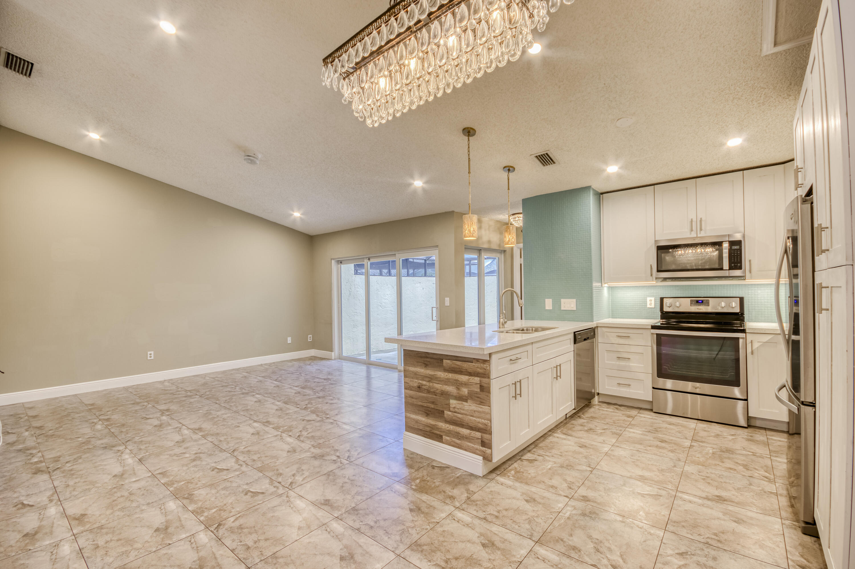9109 Southwest 21st Street, Unit E Boca Raton, FL 33428 - Photo 3 of 24 a large white kitchen with a stove a refrigerator and a sink
