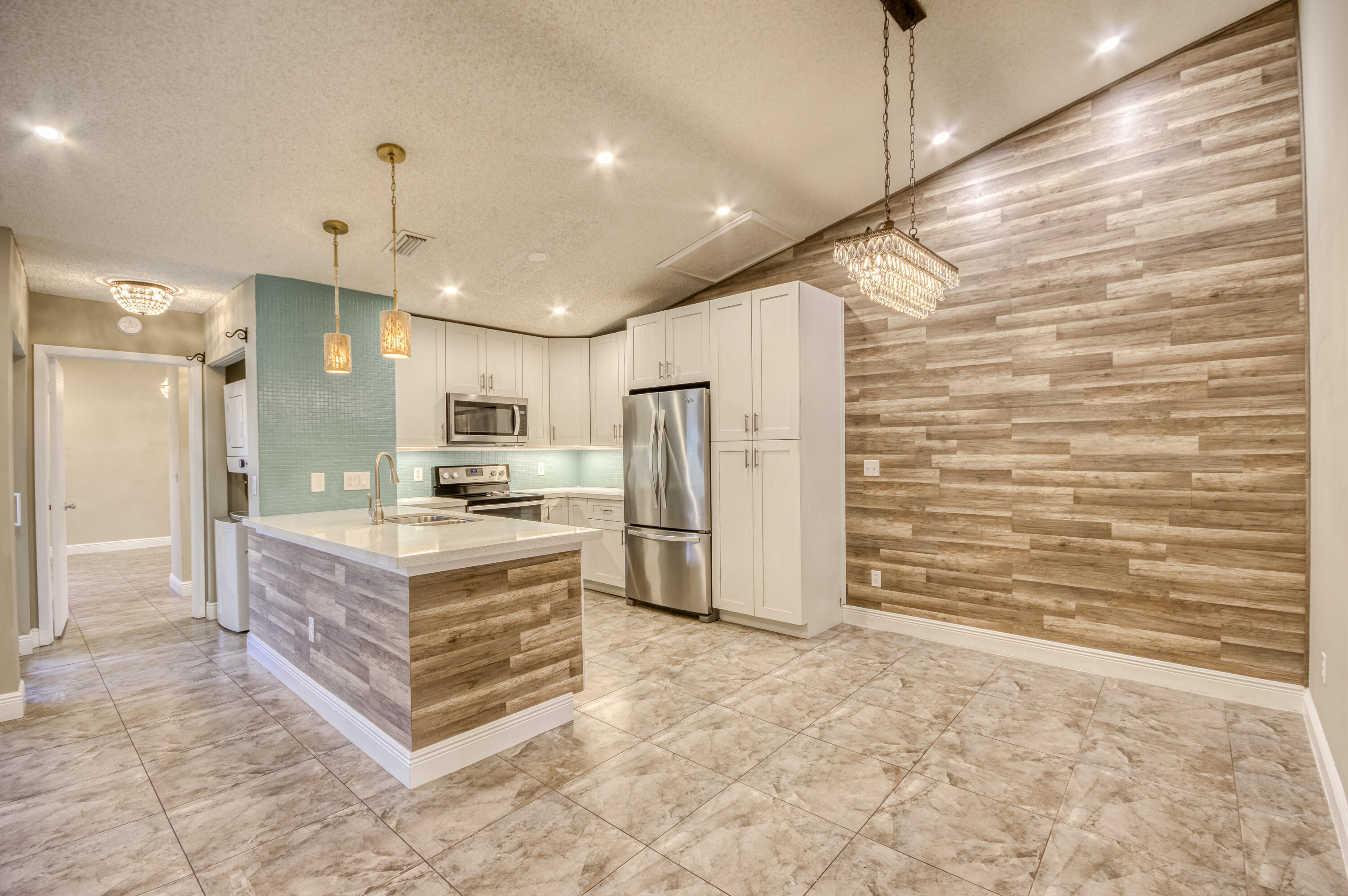 9109 Southwest 21st Street, Unit E Boca Raton, FL 33428 - Photo 8 of 24 a large kitchen with kitchen island a stove a refrigerator a sink and dishwasher