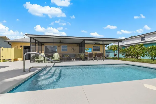 a view of a porch with dining table and chairs under an umbrella