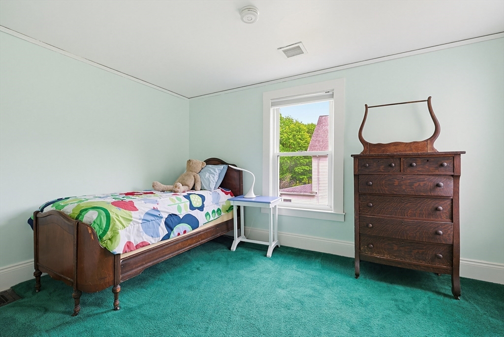 24 Riverside Place Walpole, MA 02081 - Photo 26 of 39 a bedroom with a bed and a baby crib