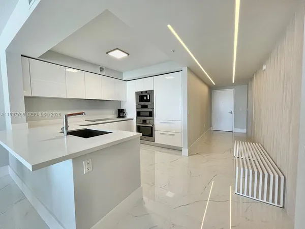 a kitchen with a sink and white cabinets